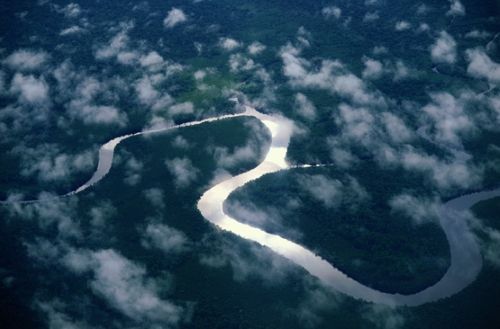 aerial view of a long winding river coursing through a lush green landscape